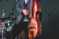 Concert view of a contrabass violoncello player with vocalist and musical rock band during jazz orchestra band performing music, Royalty Free Stock Photo