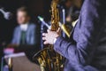 Concert view of a female saxophonist, professional saxophone player with vocalist and musical during jazz band performing music