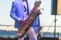 Concert view of saxophonist in a blue and white suit, a saxophone sax player with vocalist and musical band during jazz orchestra Royalty Free Stock Photo