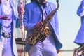 Concert view of saxophonist in a blue and white suit, a saxophone sax player with vocalist and musical band during jazz orchestra Royalty Free Stock Photo