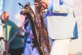 Concert view of saxophonist in a blue and white suit, a saxophone sax player with vocalist and musical band during jazz orchestra Royalty Free Stock Photo