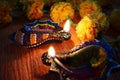 Conch shaped diyas lit glowing with flowers on background