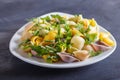 Conchiglie colored pasta with fresh greengrocery on black wooden background