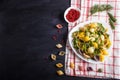 Conchiglie colored pasta with fresh greengrocery on a linen tablecloth on black wooden background