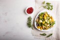 Conchiglie colored pasta with fresh greengrocery on a linen tablecloth on white wooden background