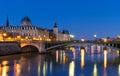 Conciergerie Building in Paris, France at night with lights reflection in the Seine River water. Royalty Free Stock Photo