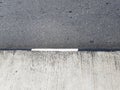 Concrete and asphalt demarcation line. Median on a road, rough cement texture