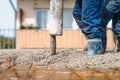 automatic pump tube working on construction site, workers directing and pouring concrete Royalty Free Stock Photo