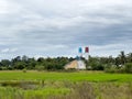 The concrete batching plant with the small crane is working near the paddy field in the countryside