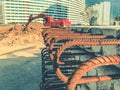 Concrete block with rusty rebar sticking out inside. fixtures for building houses. blocks on the background of a red excavator