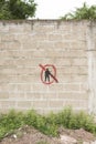 Concrete block wall with a painted symbol: a black military silhouette crossed out with red