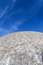 A concrete building , which looks like the spherical surface of the moon rises over the bright blue sky with clouds Royalty Free Stock Photo