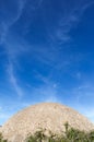 A concrete building , which looks like the spherical surface of the moon rises over the bright blue sky with clouds Royalty Free Stock Photo