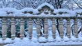 Concrete, carved gray fence with decorative patterns. Covered in snow