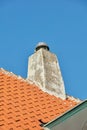 Concrete chimney designed on slate house roof or building outside against clear blue sky background, copyspace