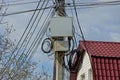 Concrete column with a black cable and electric wires and an iron gray box Royalty Free Stock Photo