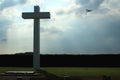 Concrete cross with cloudy sky and sport plane