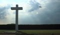 Concrete cross with cloudy sky and sports plane