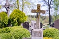 Concrete cross with crucifix in cemetery in summer