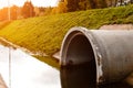 Concrete culvert pipe hole system draining sewage water in rays Royalty Free Stock Photo
