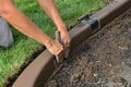 Concrete curb edging being shaped for smoothness in a flower bed Royalty Free Stock Photo