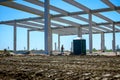 Concrete edifice under construction with mobile plastic toilet