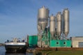 Concrete factory with waiting ship in sunset