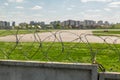 Concrete fence with barbed wire around airport airfield taxiway against blue sky on background. Freedom and security Royalty Free Stock Photo