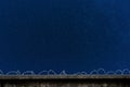 Concrete fence with barbed wire and starry sky