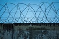 Concrete fence with barbed wire. Prison walls with barbed wire on a blue sky Royalty Free Stock Photo