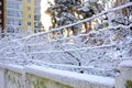 Concrete fence barbed wire snow with a multi-storey house in the background. Royalty Free Stock Photo