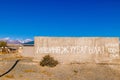 concrete fence with large inscription translating from Kyrgyz car washing prohibited, fine 500 som