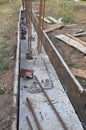 The concrete footer installed along the length of this fence. Pour concrete footings in wooden slabs with reinforcing bars for new