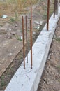 The concrete footer for new fence mounting. Fence footings. Close up on reinforced concrete footing for fence foundation with Royalty Free Stock Photo