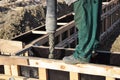 Concrete footing construction. A building contractor is pouring a concrete slab into a timber concrete formwork for a concrete