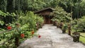 A concrete footpath leads directly to the wooden cottage.