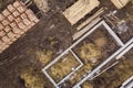 Concrete foundation for basement of future house, stacks of bricks and building timber logs for construction on sunny summer day,