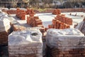 Concrete foundation with bricks for laying. Stack of red bricks on concrete foundation, process of house building. Building