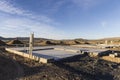 Concrete foundation sits ready for house framing on an empty lot