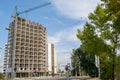 Concrete frame of tall apartment building under construction and tower crane in a city Royalty Free Stock Photo