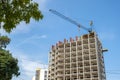 Concrete frame of tall apartment building under construction and tower crane in a city Royalty Free Stock Photo