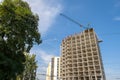 Concrete frame of tall apartment building under construction and tower crane in a city Royalty Free Stock Photo