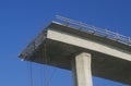 A concrete freeway structure ends abruptly with iron support structures sticking out and safety rails lining the top edge until Royalty Free Stock Photo