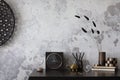 Concrete interior of home office with desk, image, lamp and office accessories. Grey concrete wall. Home decor. Template
