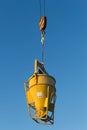 Concrete machine for spreading cement hoisted at building site on blue sky background