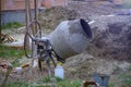 Concrete mixer in construction. Cement mixer at a construction site, tools, a pile of sand and a bucket Royalty Free Stock Photo