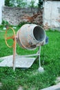 Concrete mixer on a green grassy lawn. Construction, repair