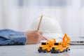 Concrete mixer truck and excavator on architect`s desk, Engineering objects, Construction site