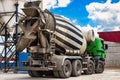 Concrete mixer truck in front of a concrete batching plant, cement factory. Loading concrete mixer truck. Close-up. Delivery of Royalty Free Stock Photo