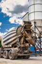 Concrete mixer truck in front of a concrete batching plant, cement factory. Loading concrete mixer truck. Close-up. Delivery of Royalty Free Stock Photo